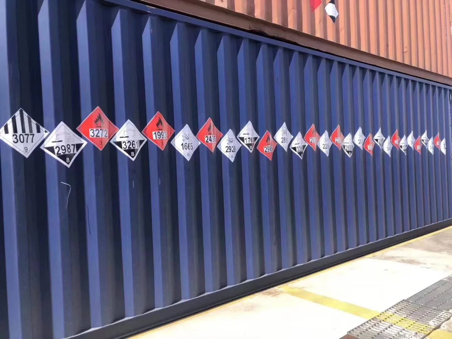A row of dangerous goods placards on a blue container
