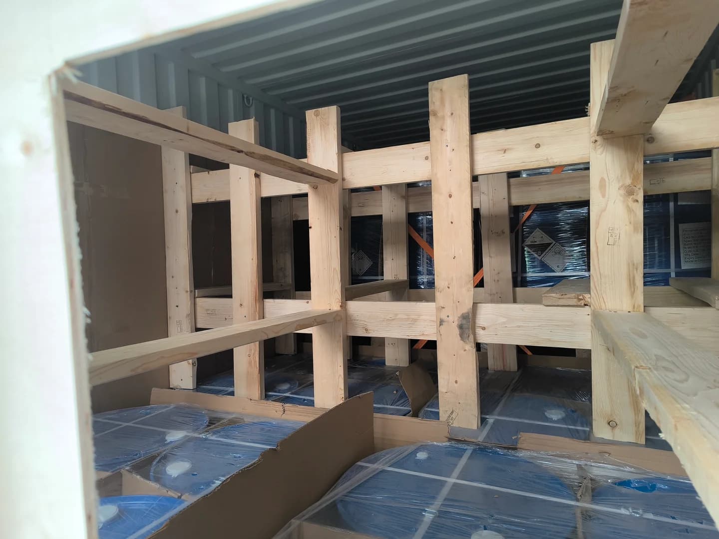 Historical work photograph: timber bracing around drummed cargo.