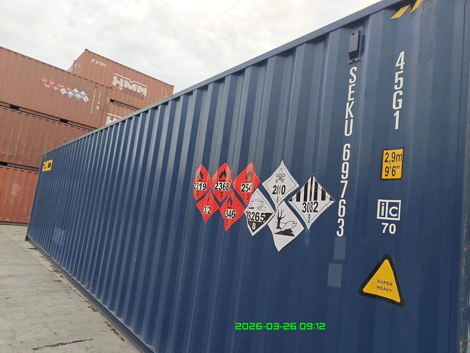 Shipment photograph: container and DG placards; the final two container-ID characters are locally masked.