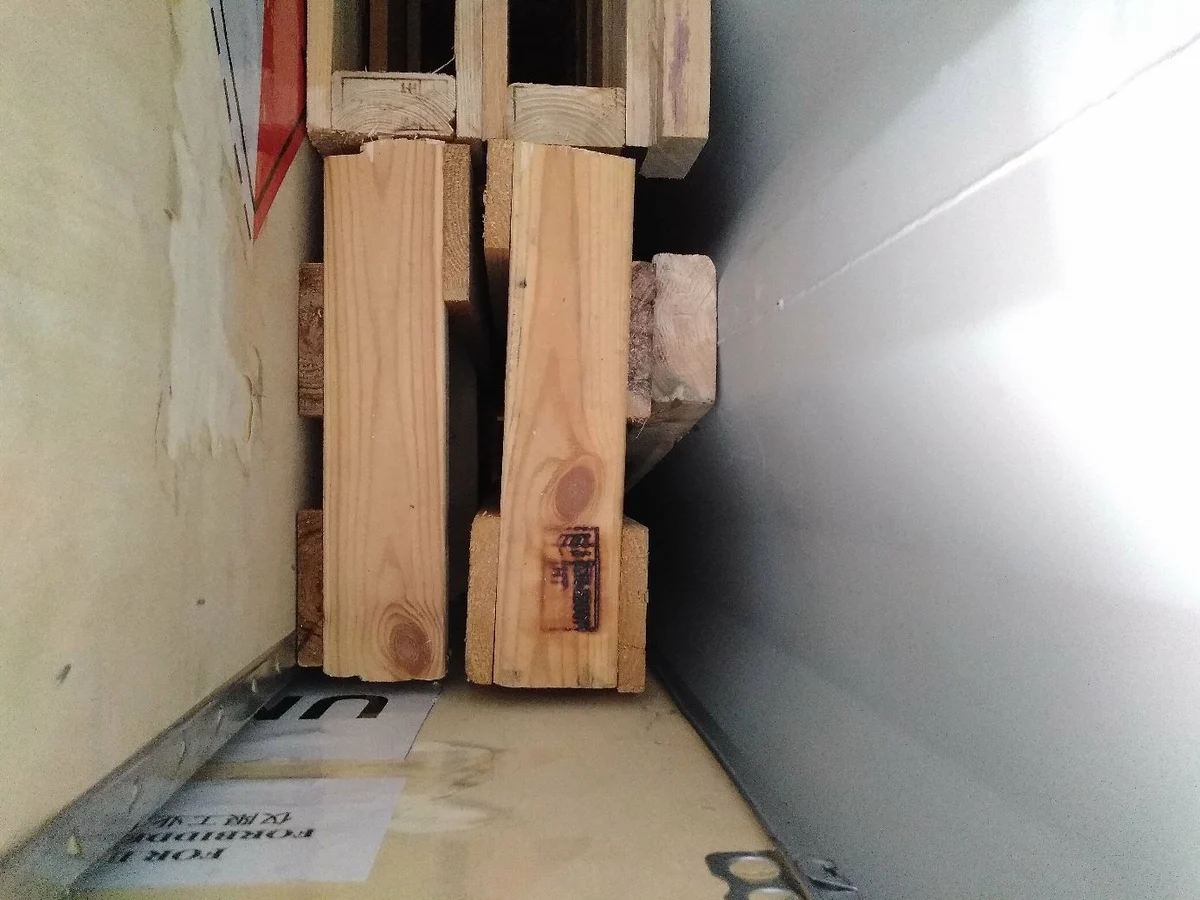 Shipment photograph: timber blocking between a crate and the container wall.